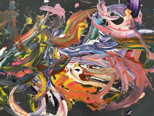 Abstract pour painting of colorful swirling ribbons of paint on a black background