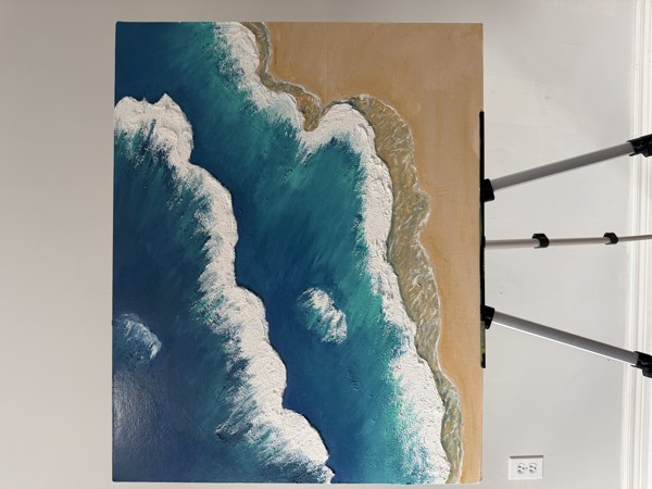 Textured painting of ocean waves with white foam meeting a sandy beach, seen from above